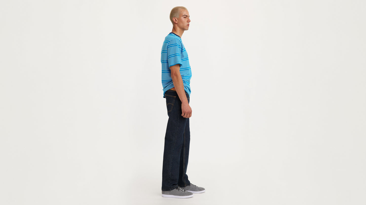 Man in stripe shirt and straight Levi's jeans side view