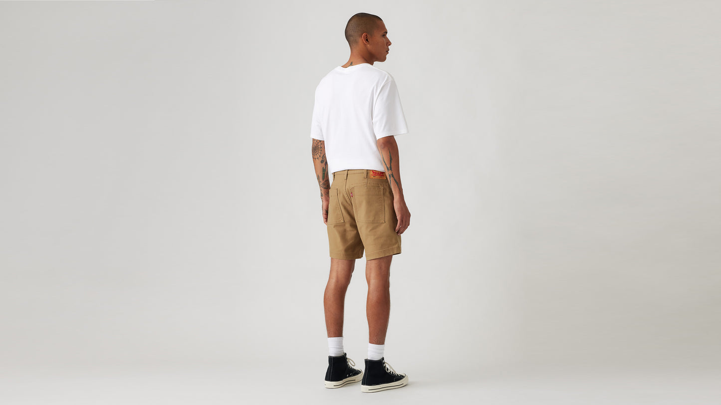 Man in Levi's brown shorts and white tee, back view