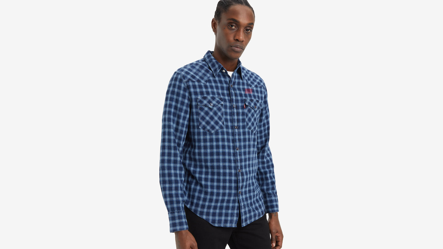 Man wearing blue checkered shirt and black pants