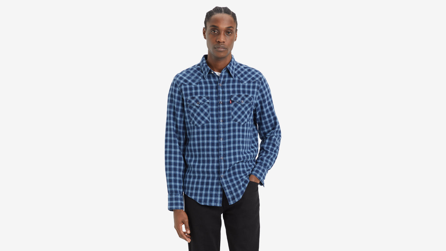 Man in blue plaid shirt with hand pocketed