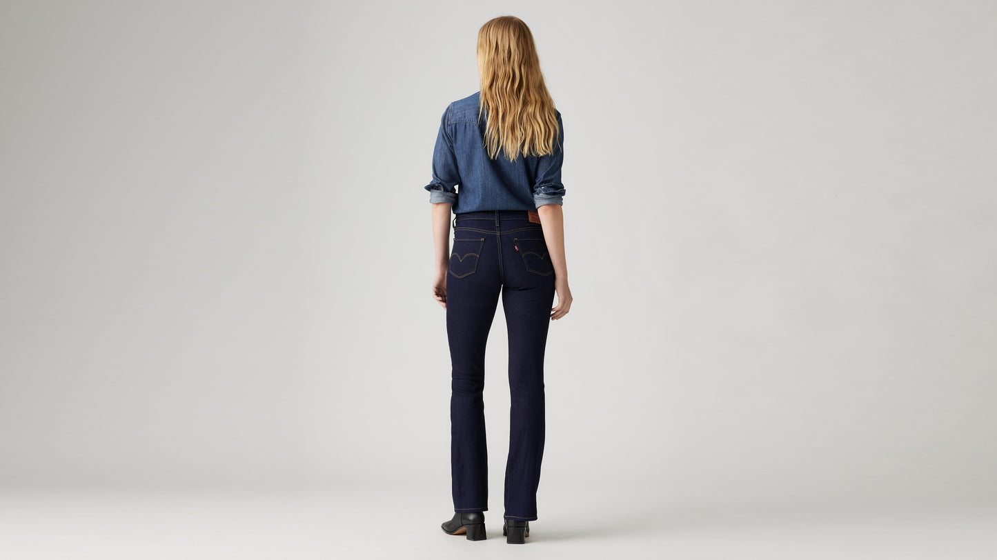 Woman in dark blue bootcut jeans, back view