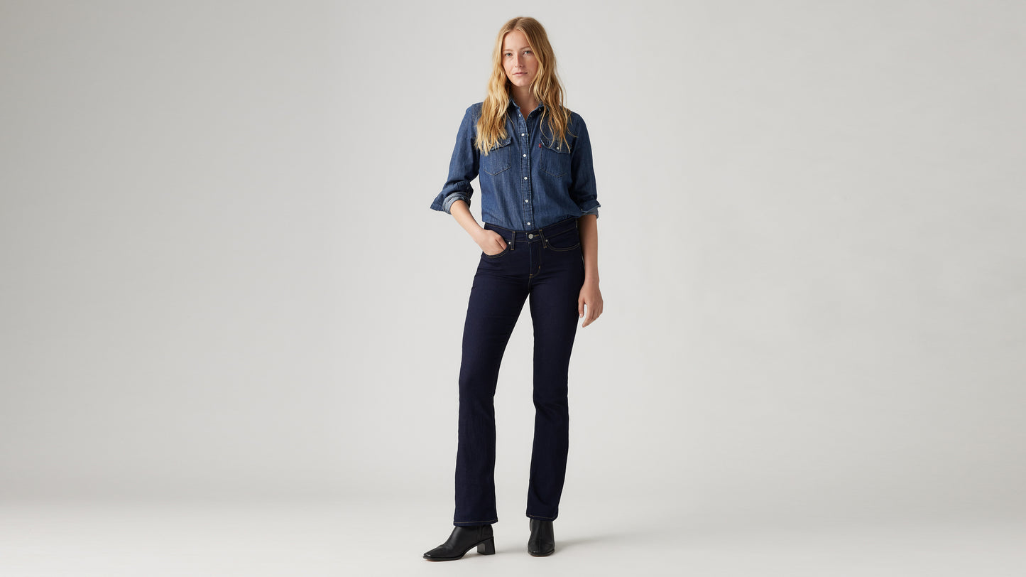 Woman in dark blue bootcut jeans and denim shirt