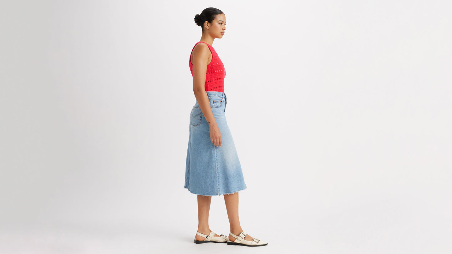 Woman in Levi's high-rise a-line skirt and red top side view