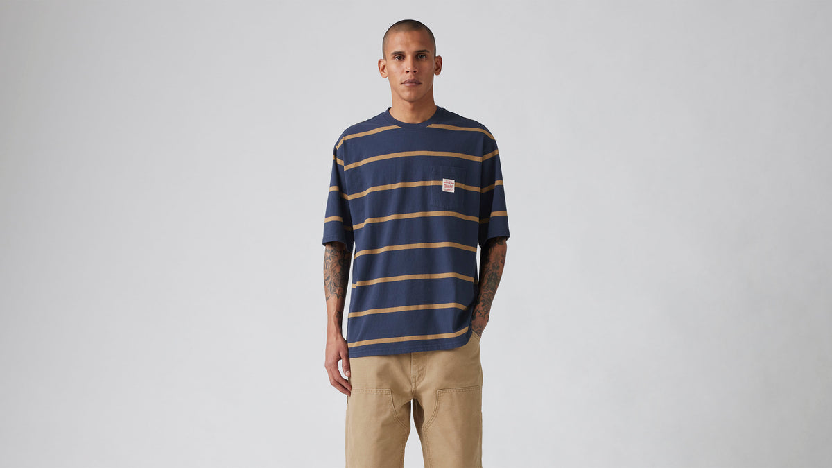 Model wears navy Levi’s striped tee and khaki pants