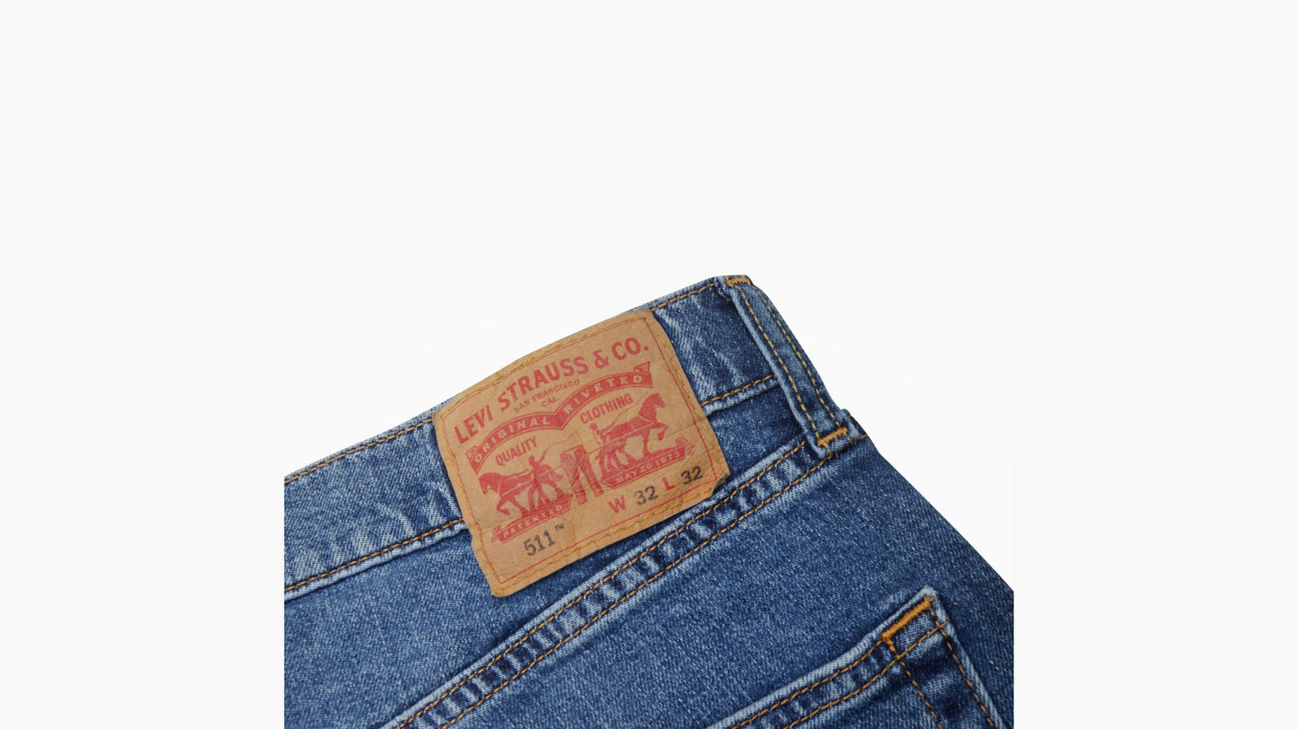 Close-up of Levi’s 511 medium blue jeans showing branded leather patch on waistband