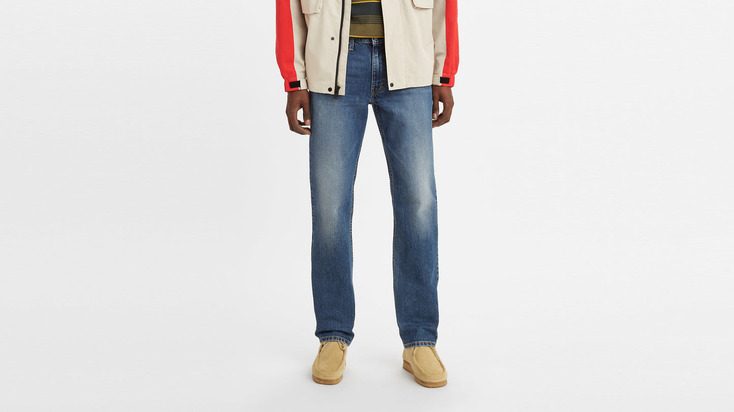Front view of a man wearing faded blue Levi’s 514 jeans paired with tan suede shoes