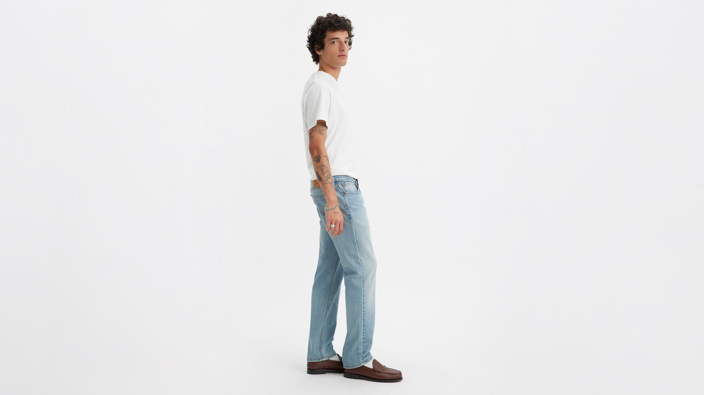 Side view of a person wearing light blue Levi’s 514 jeans, white tee, and loafers