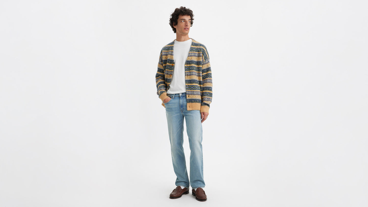 Front view of a man in light blue Levi’s 514 jeans, white tee, patterned cardigan & loafers.