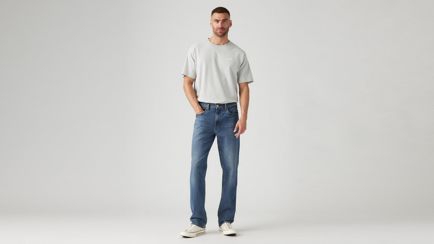Front view of a man in a grey t-shirt, Levi's straight-leg blue jeans, & sneakers