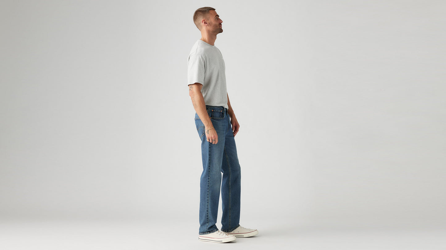 Side view of man in a gray t-shirt paired with Levi’s Straight jeans, & sneakers