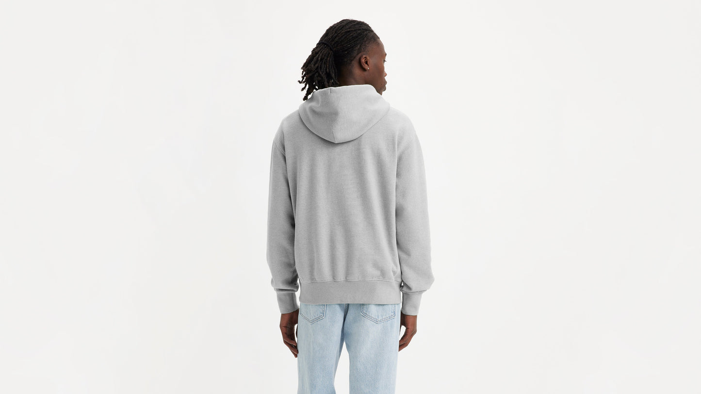 Man in grey Levi's Men's Authentic Hoodie with light wash jeans facing backward