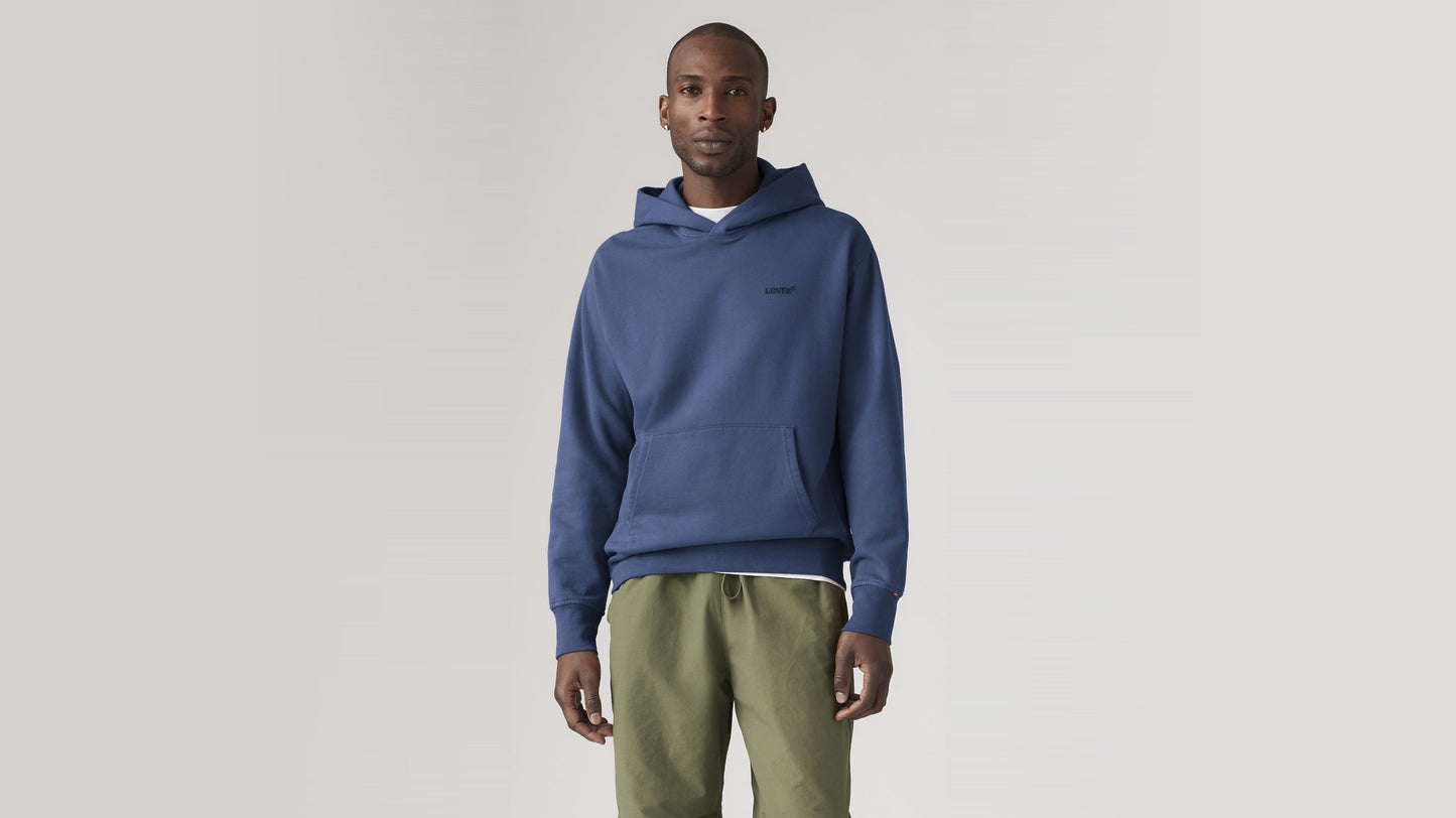 Man in blue Levi's hoodie styled with olive green drawstring pants, front view