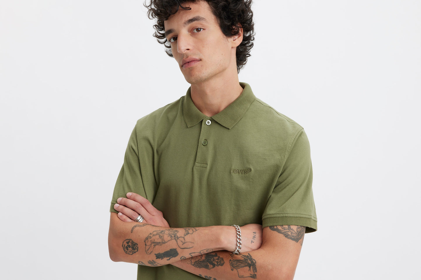 Close-up of model wearing green Levi's polo shirt