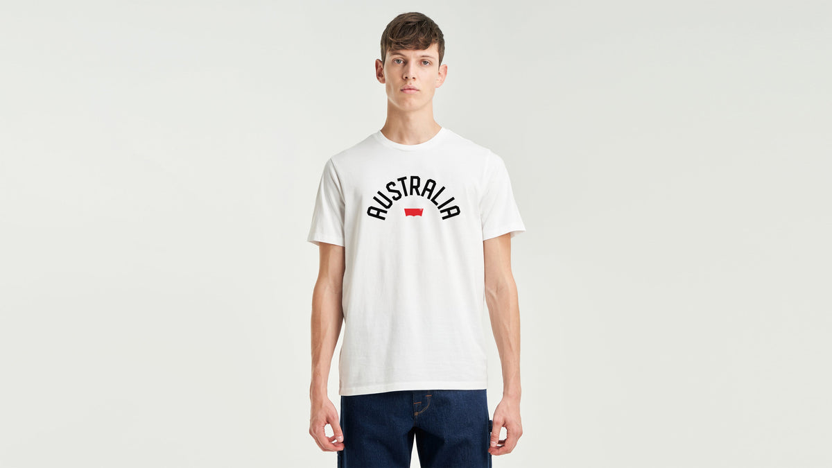 Front view of man in white Levi's Australia tee and dark jeans