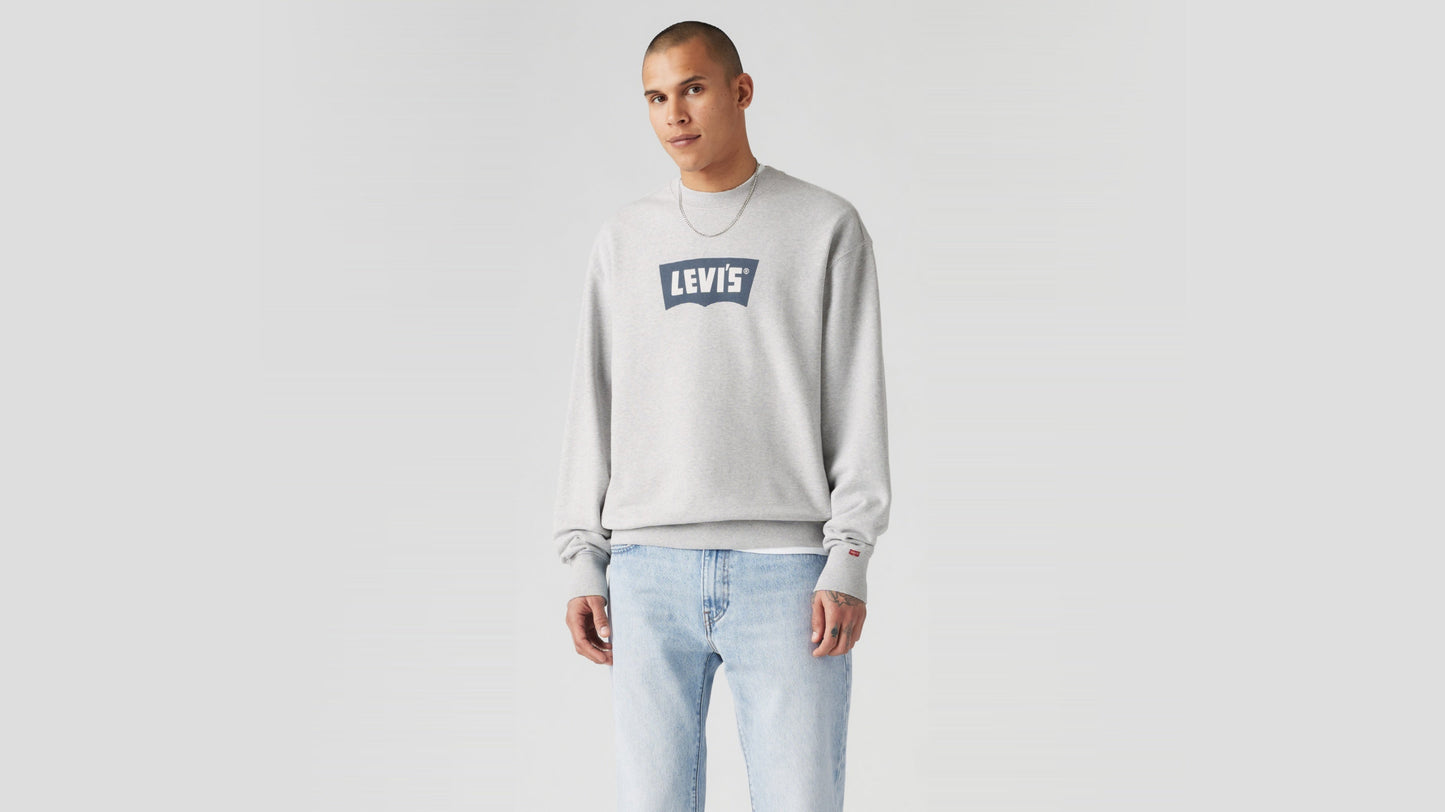 Man in light blue Levi’s jeans and grey logo sweatshirt