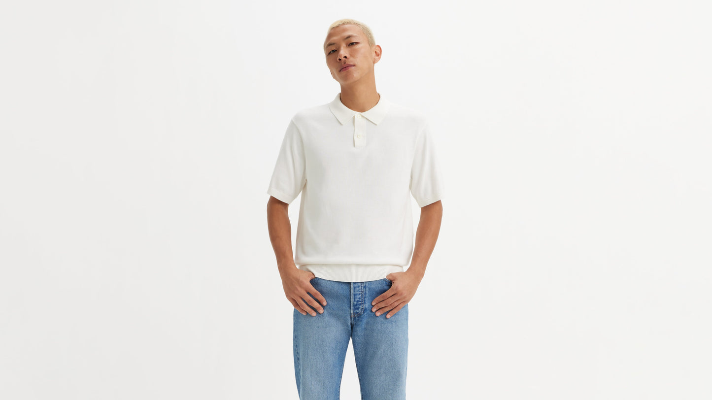 Front view model in white Levi's polo shirt with jeans, hands in pockets