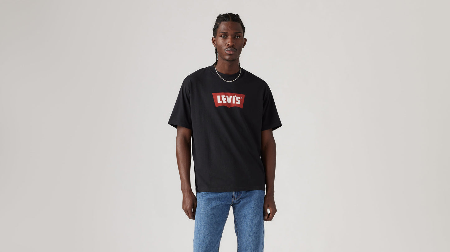Front view of man in black Levi's Batwing Graphic Tee with light wash jeans