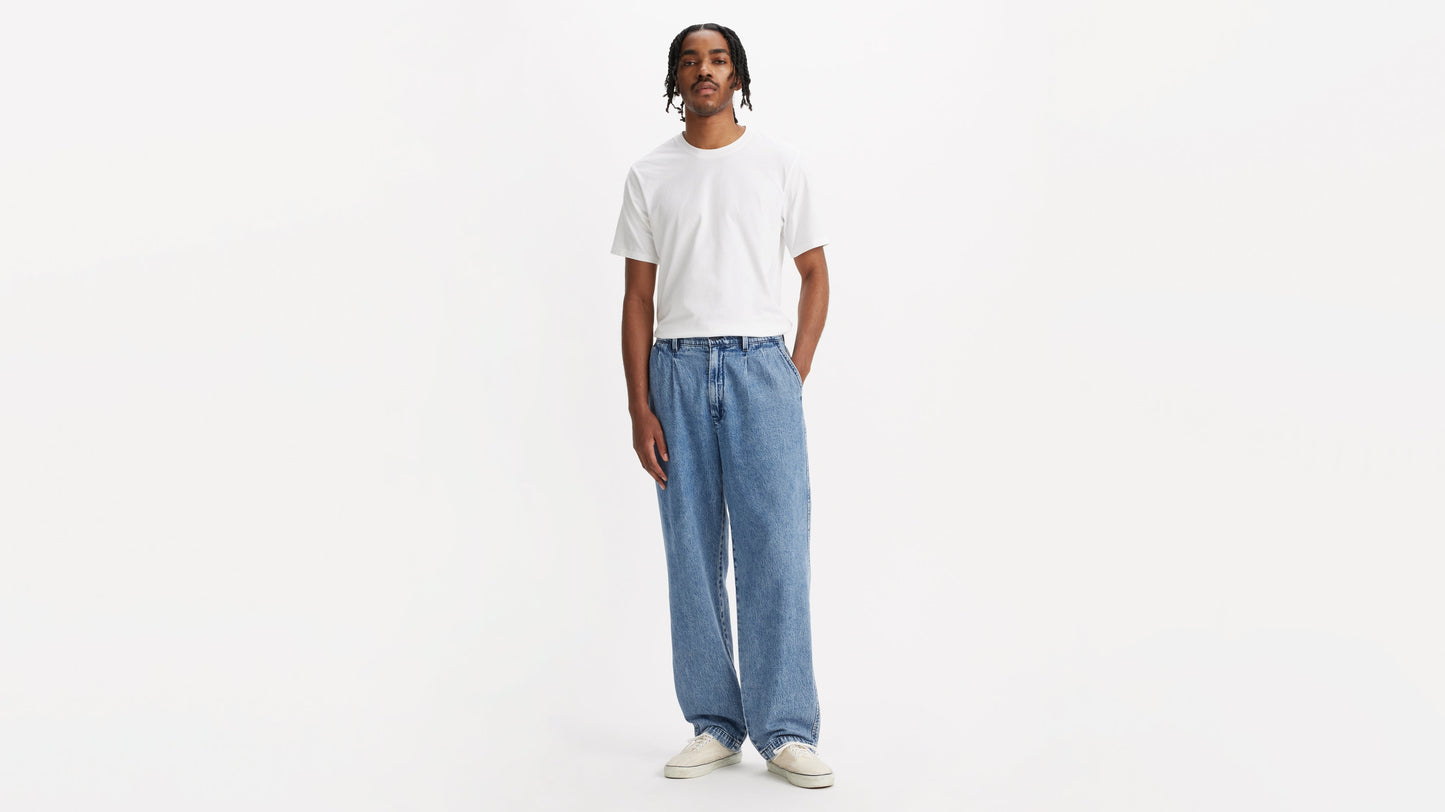 Front view of man in chino loose straight pants and plain tee, hands by his sides