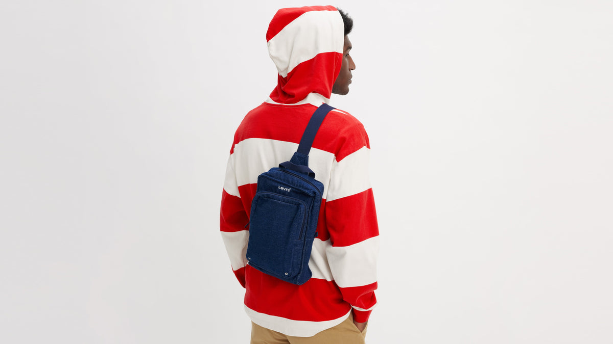 Model in striped hoodie and Levi's zip sling bag