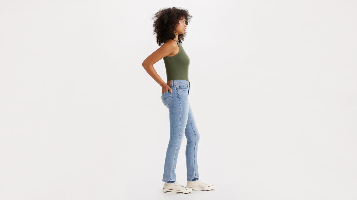 Side view of a woman in light blue 314 straight jeans with olive tank top