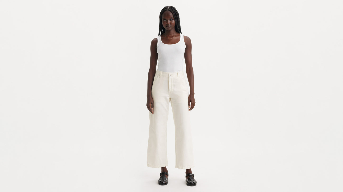 Front view of model wearing off-white Levi’s carpenter jeans with white top