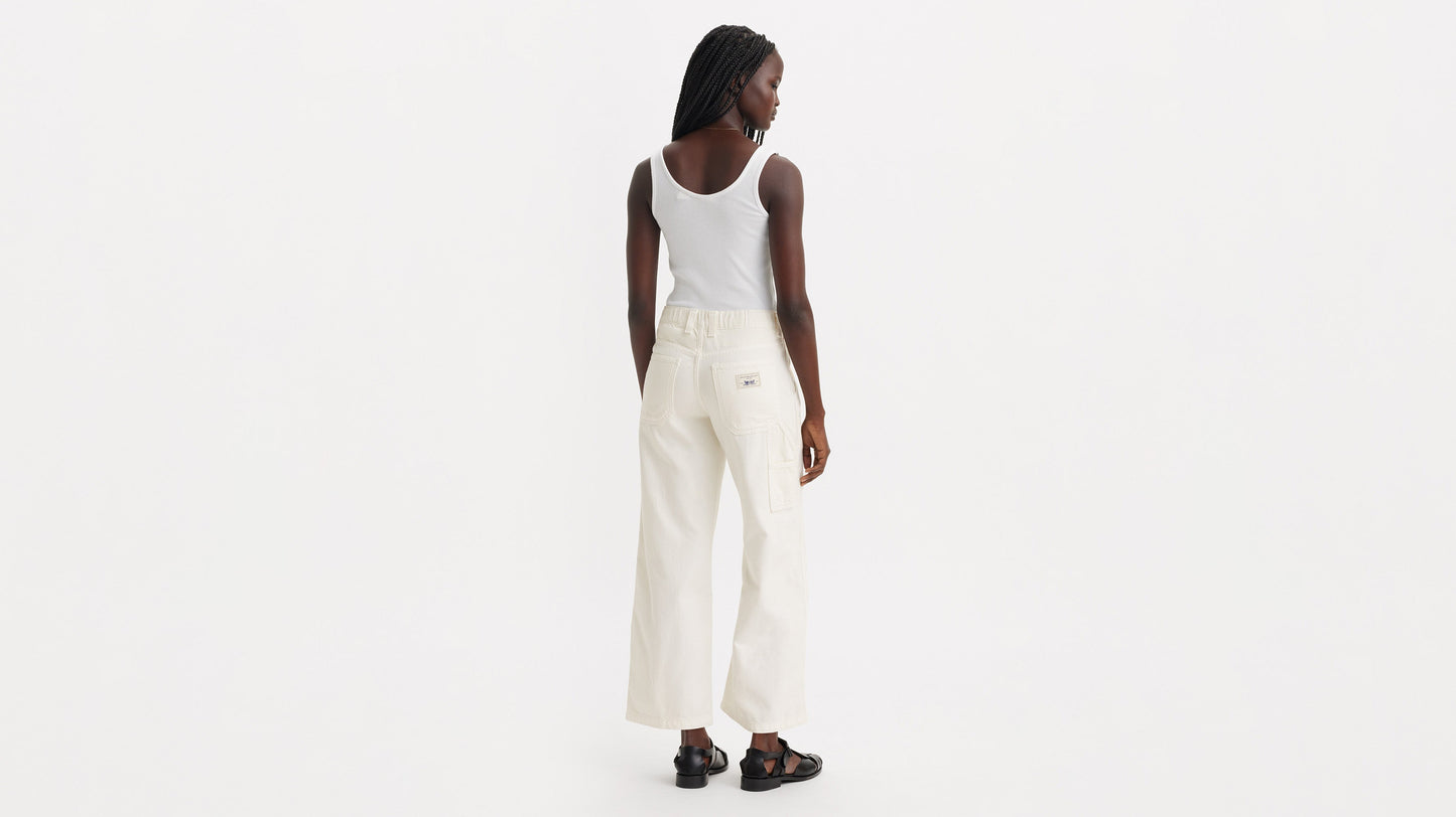 Model wearing off-white Levi’s carpenter jeans with white top, back view