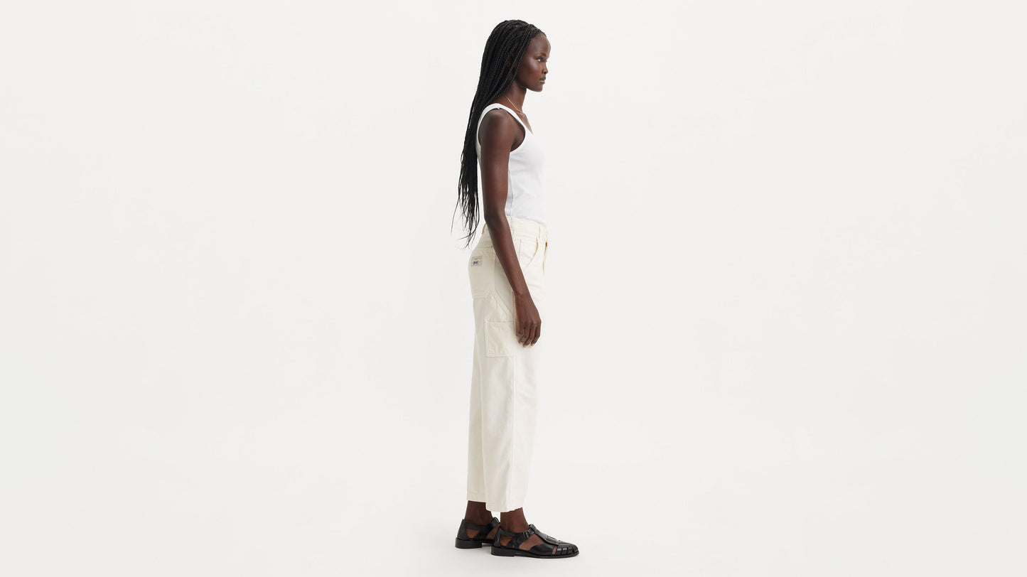 Side view of model in off-white Levi’s carpenter jeans with white top