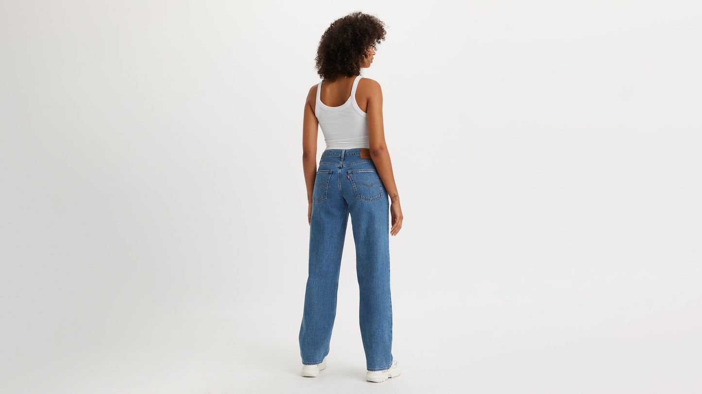 Back view of a woman in blue Levi's Baggy Jeans & white tank top