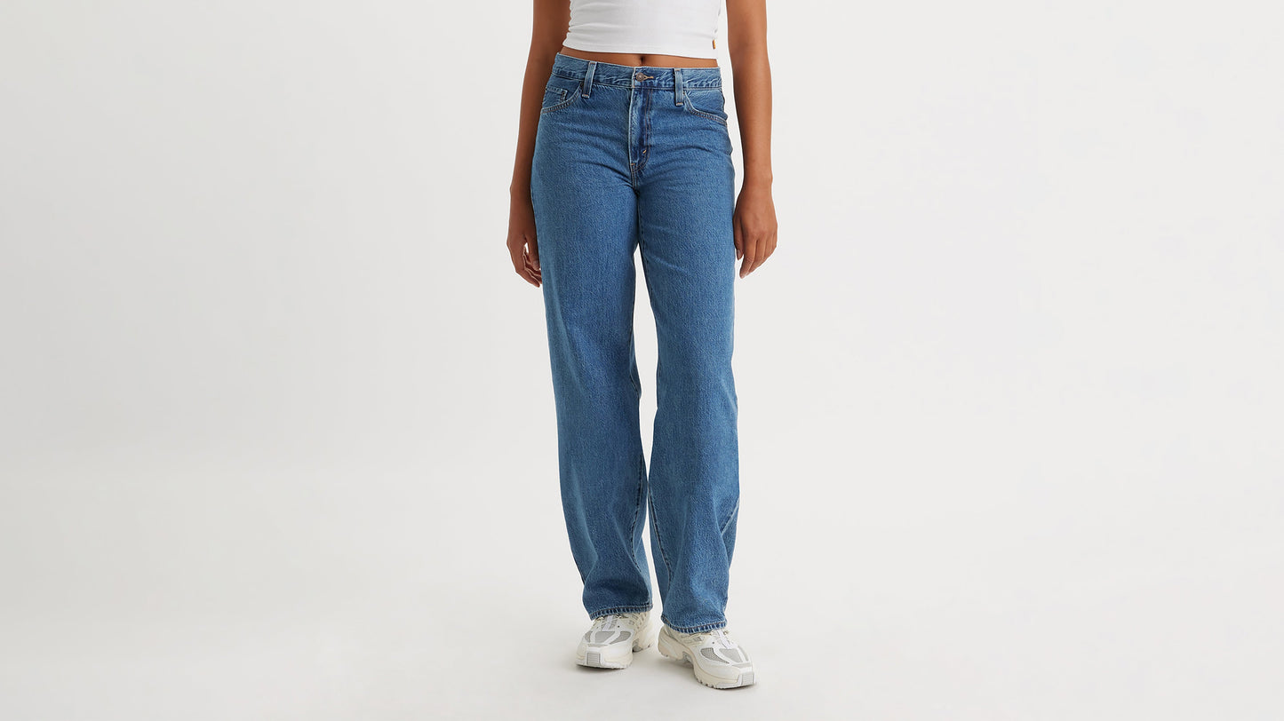 Half-body shot of a woman in blue Levi's Baggy Jeans & sneakers