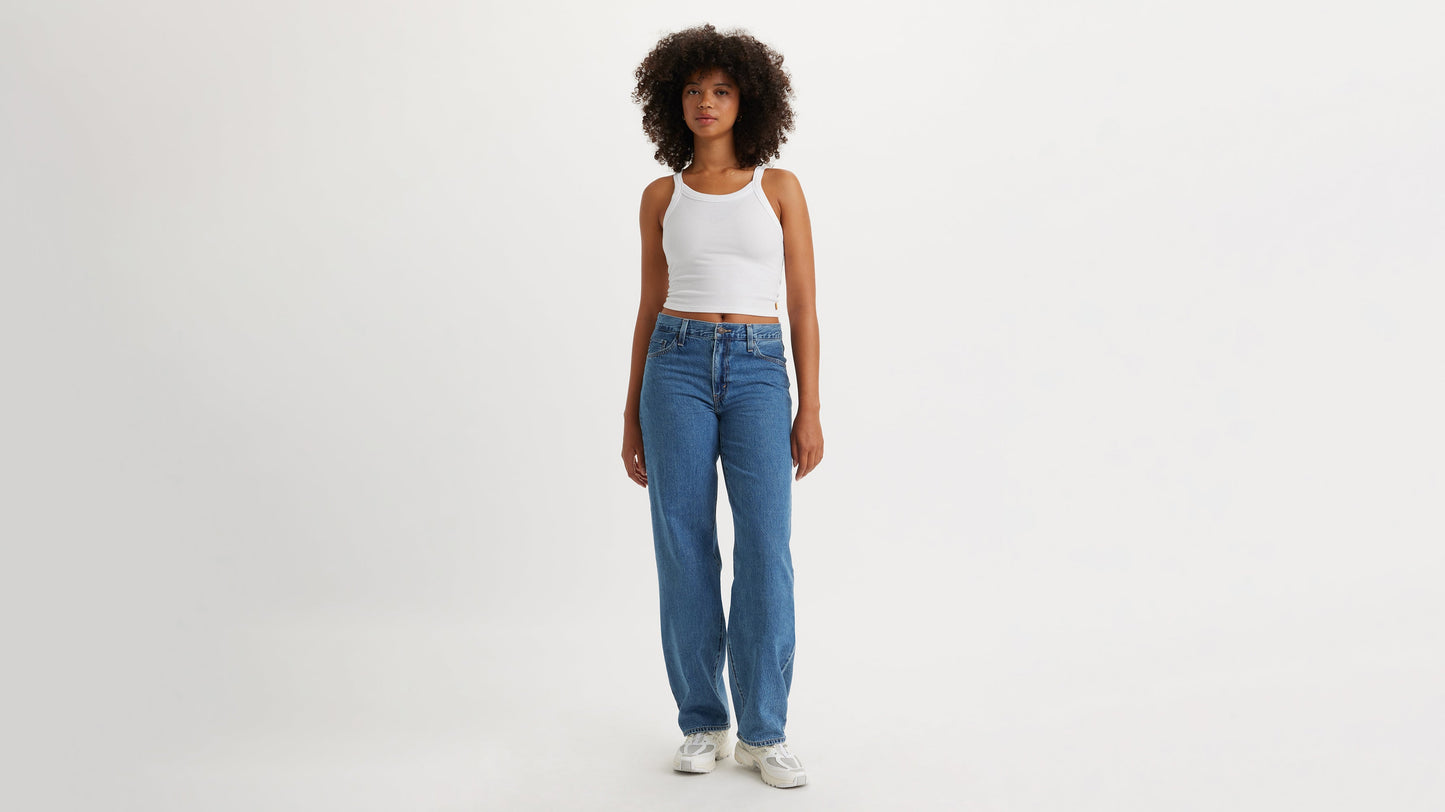 Front view of a woman in blue Levi's Baggy Jeans & white tank top