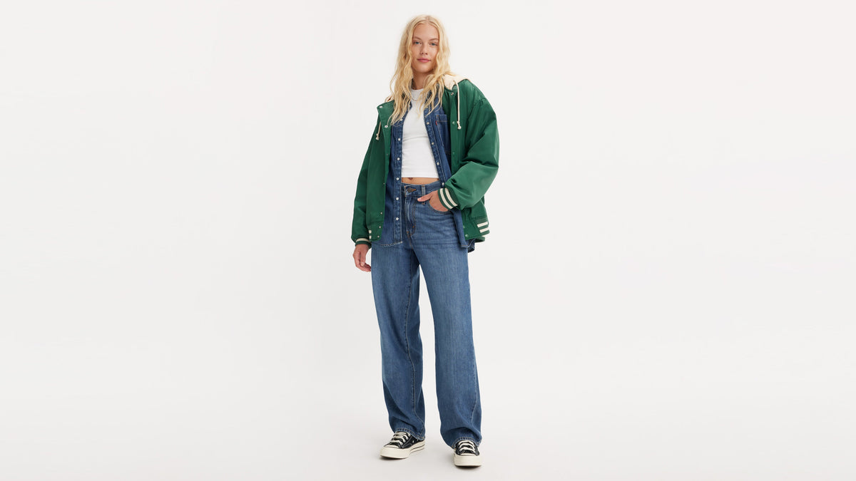 Woman in green varsity jacket layered over denim vest & Levi's baggy jeans