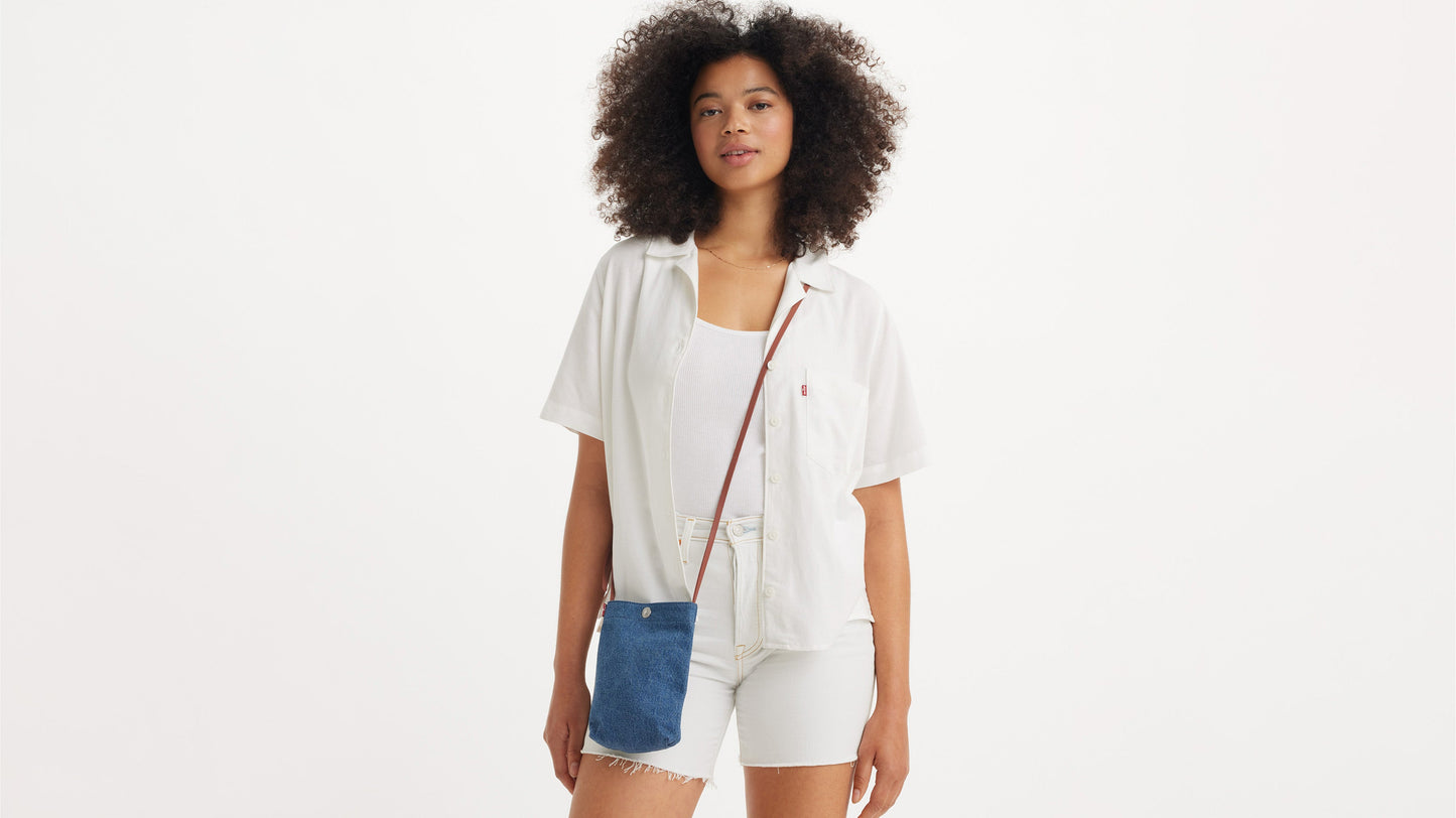 Woman in white Levi’s outfit with denim phone pouch