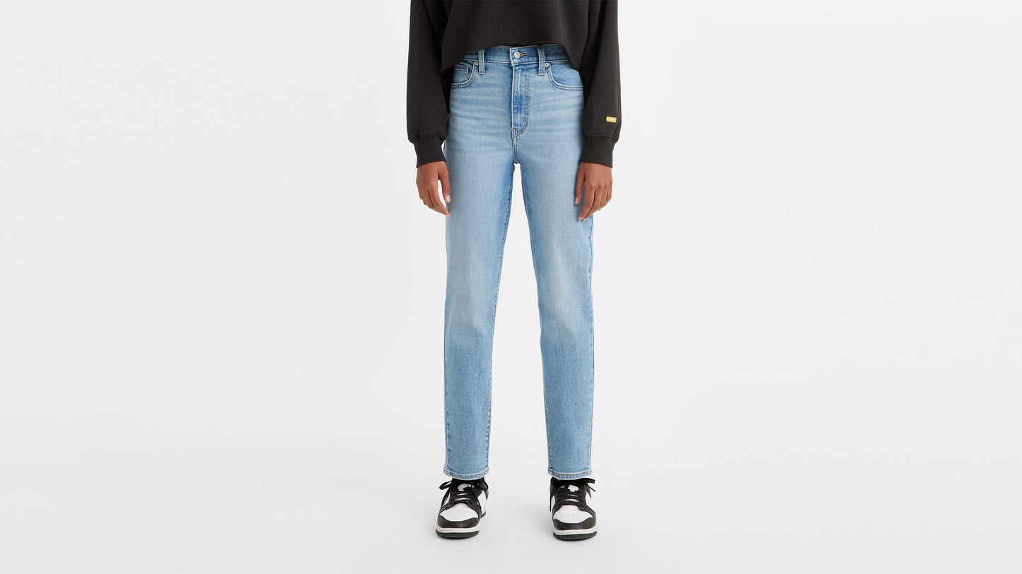 Model wearing high-waisted mom jeans paired with black & white sneakers