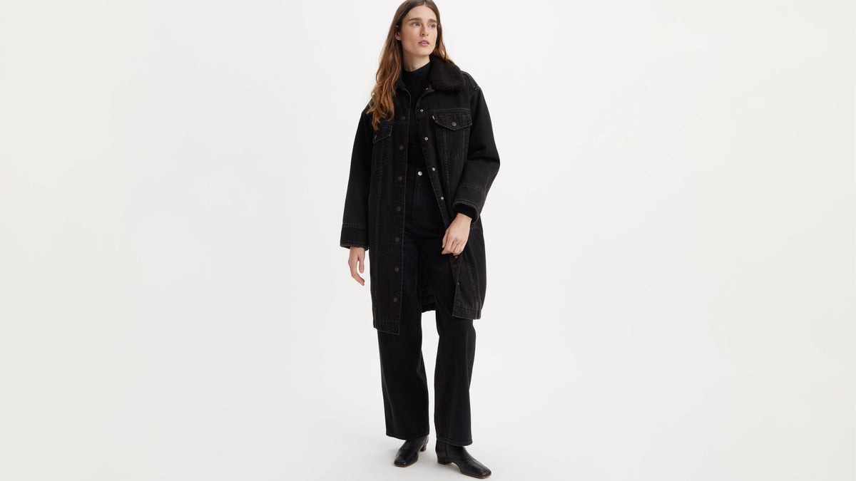 Woman in full-length black Levi’s trucker jacket and black jeans