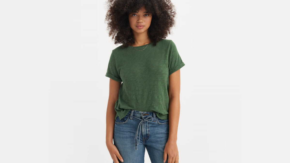 Woman in green Levi’s tee and mid-wash jeans