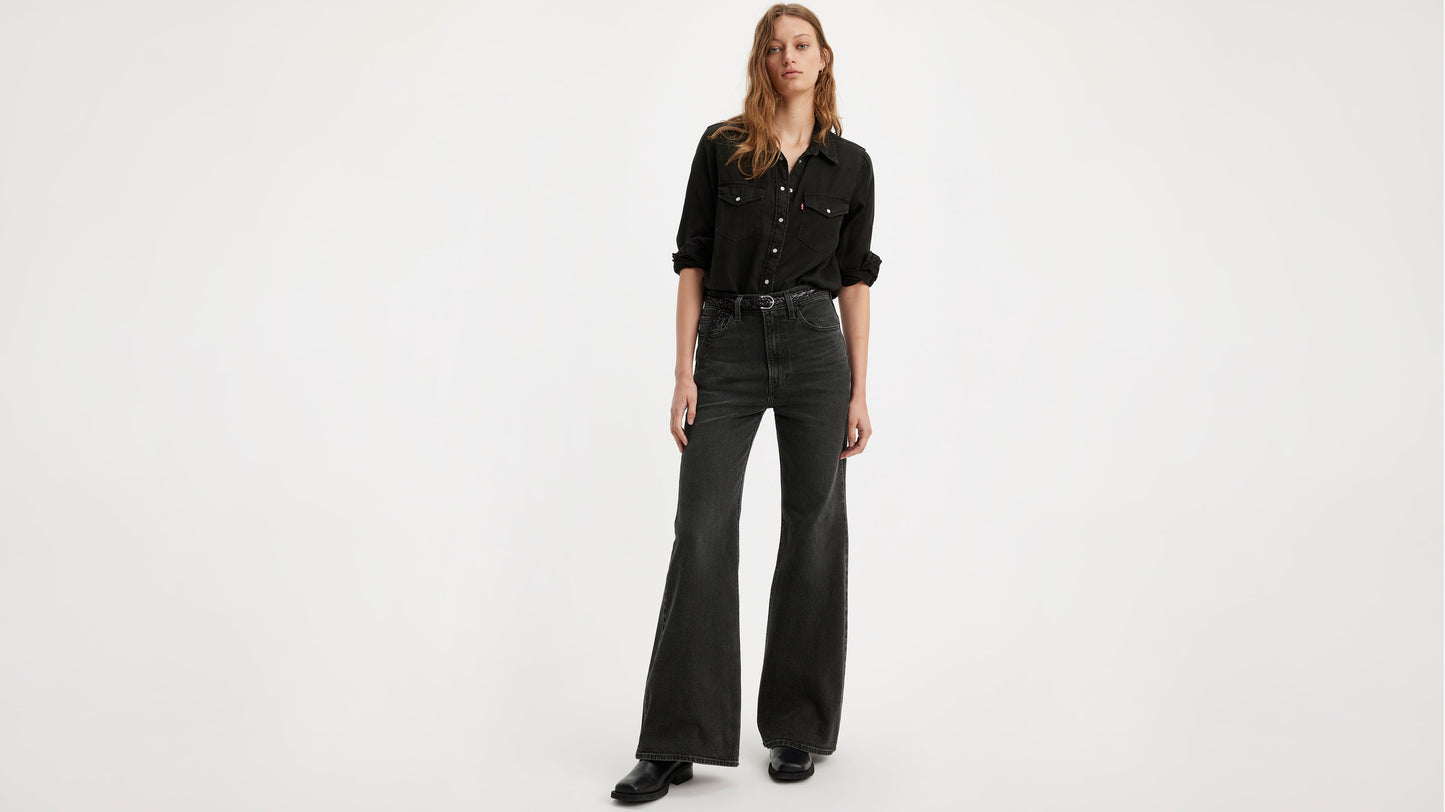 Model wearing a black button-up shirt tucked into Levi's ribcage bell jeans