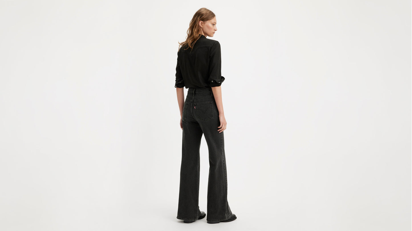Model in a black button-up shirt & Levi's ribcage bell jeans, back view