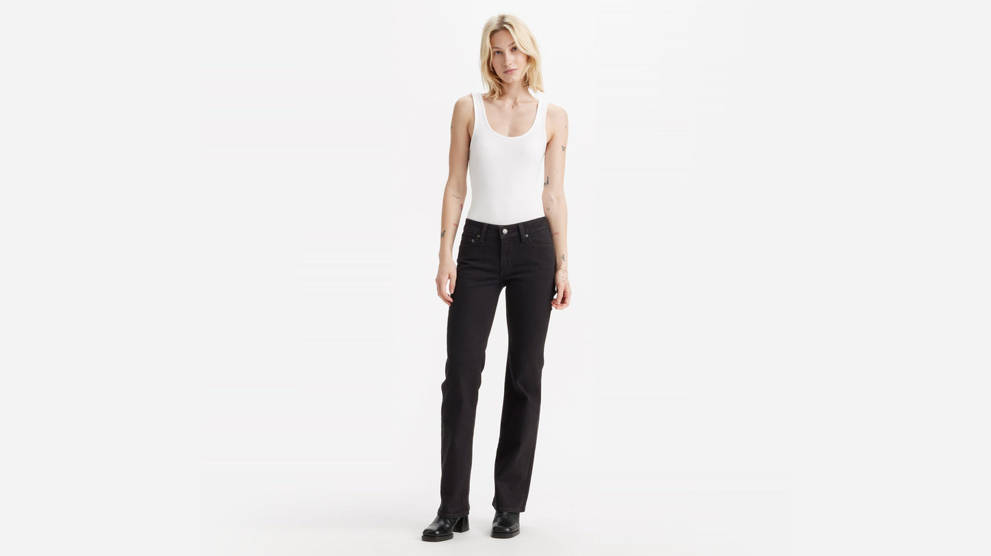 Front view of woman wearing Levi's Superlow Bootcut Jeans with white tank top