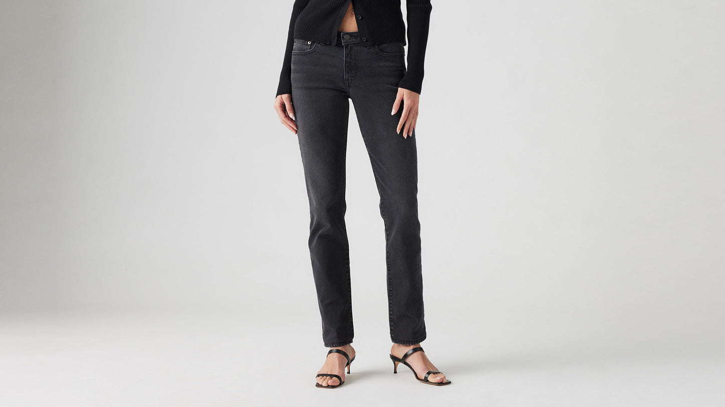 Cropped front view of model in black Levi’s superlow skinny jeans & black heels