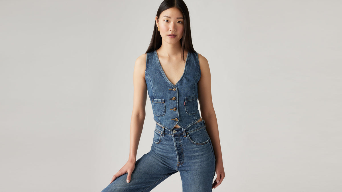 Woman in dark blue Levi’s jeans and denim vest