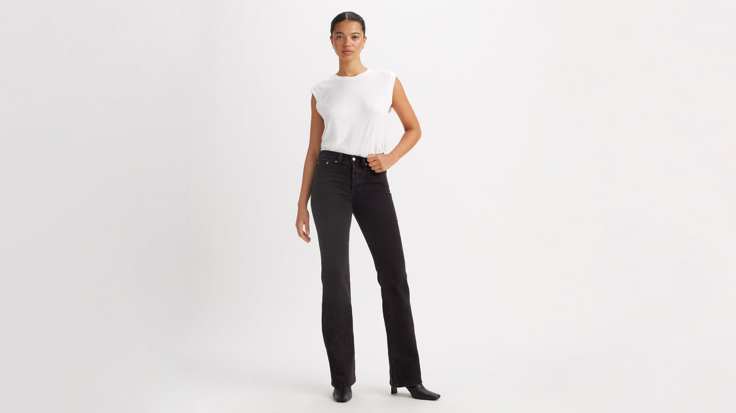 Woman in white top, black Levi's Wedgie Jeans, & black boots, front view
