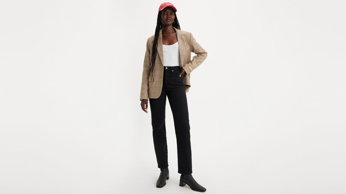 Woman wearing Levi's black jeans, blazer, tank top, and cap