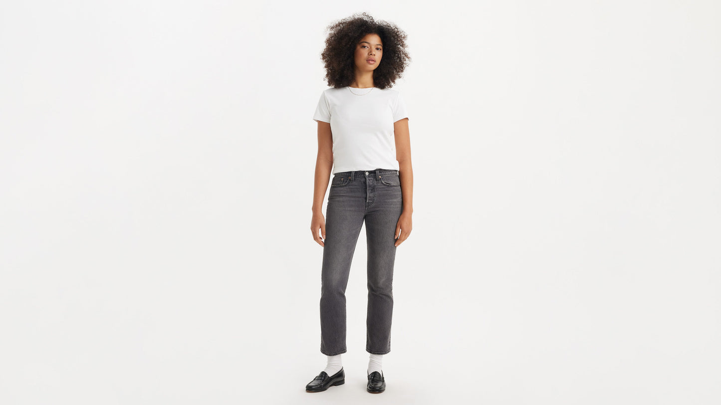 Woman in black loafers, grey straight jeans, & white tee, front view