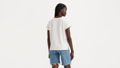 Woman in white shirt and denim shorts, back view