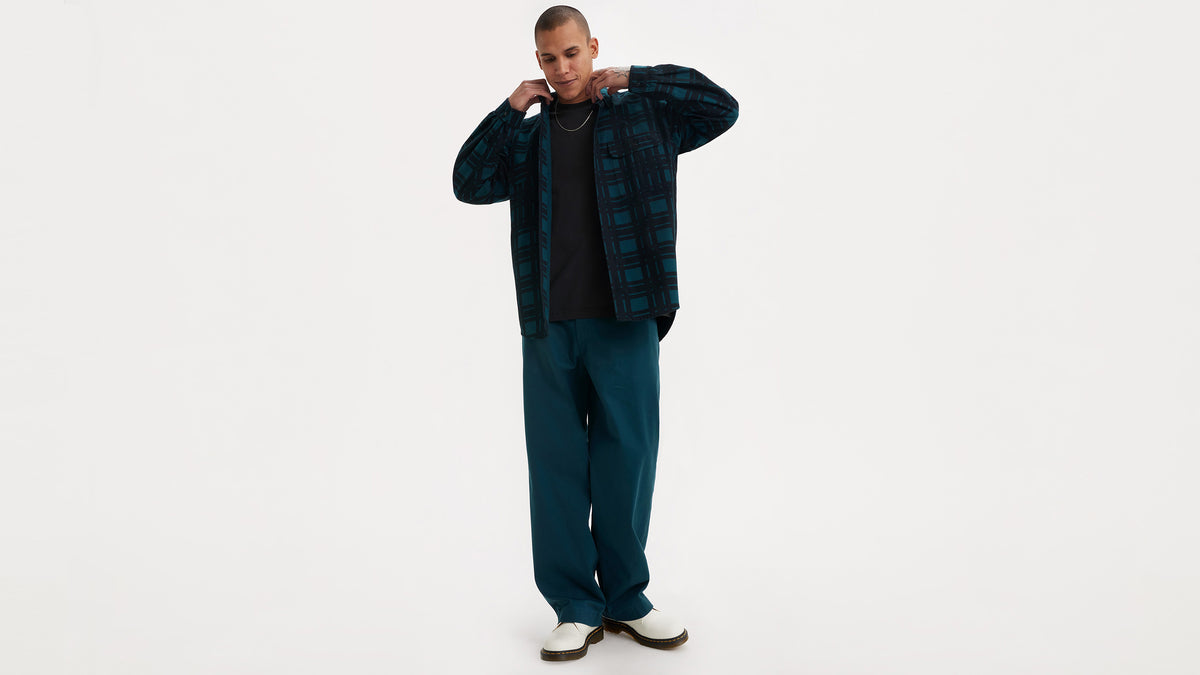 Man in teal pants and checkered shirt