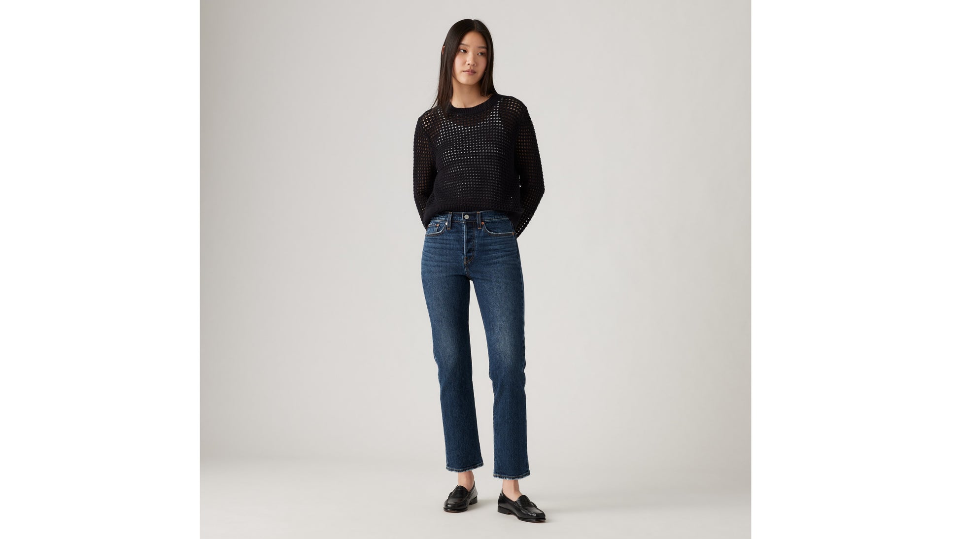 Woman in Levi's black mesh sweater and blue jeans