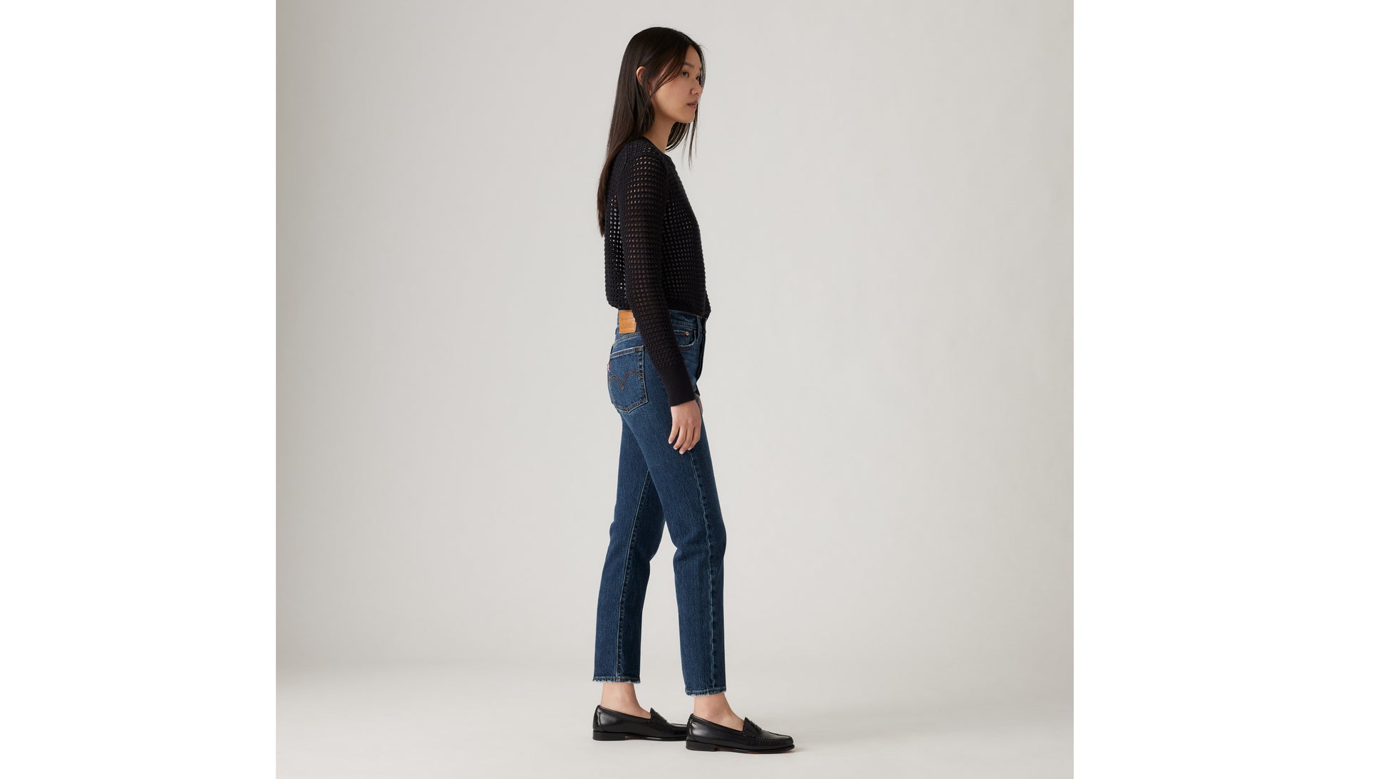 Woman in black mesh sweater and blue jeans