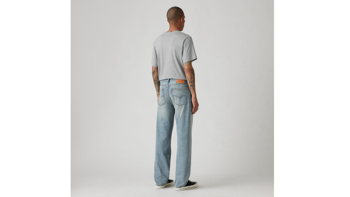 Man in Levi's grey tee and light-blue jeans, back view