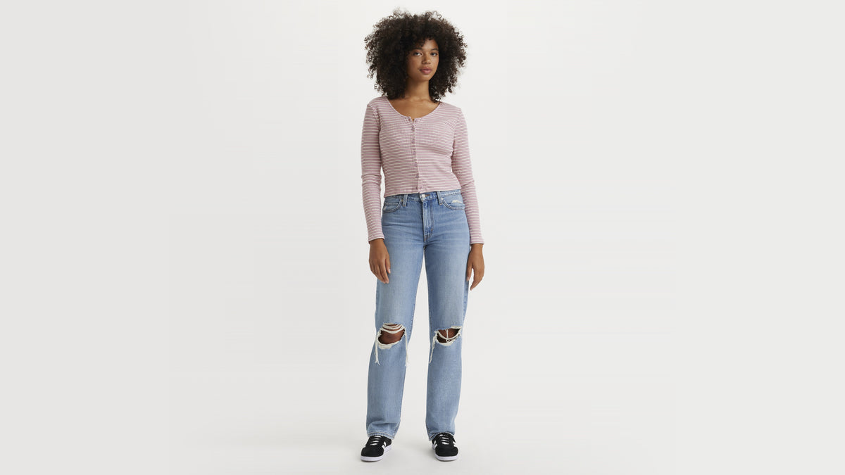 Woman in ripped light-wash jeans and striped top