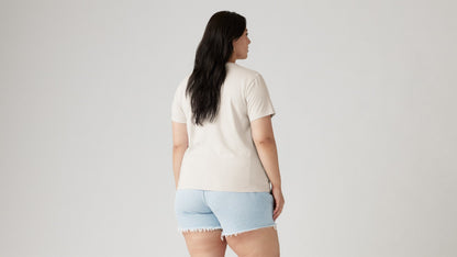 Woman in off-white tee and blue ripped shorts